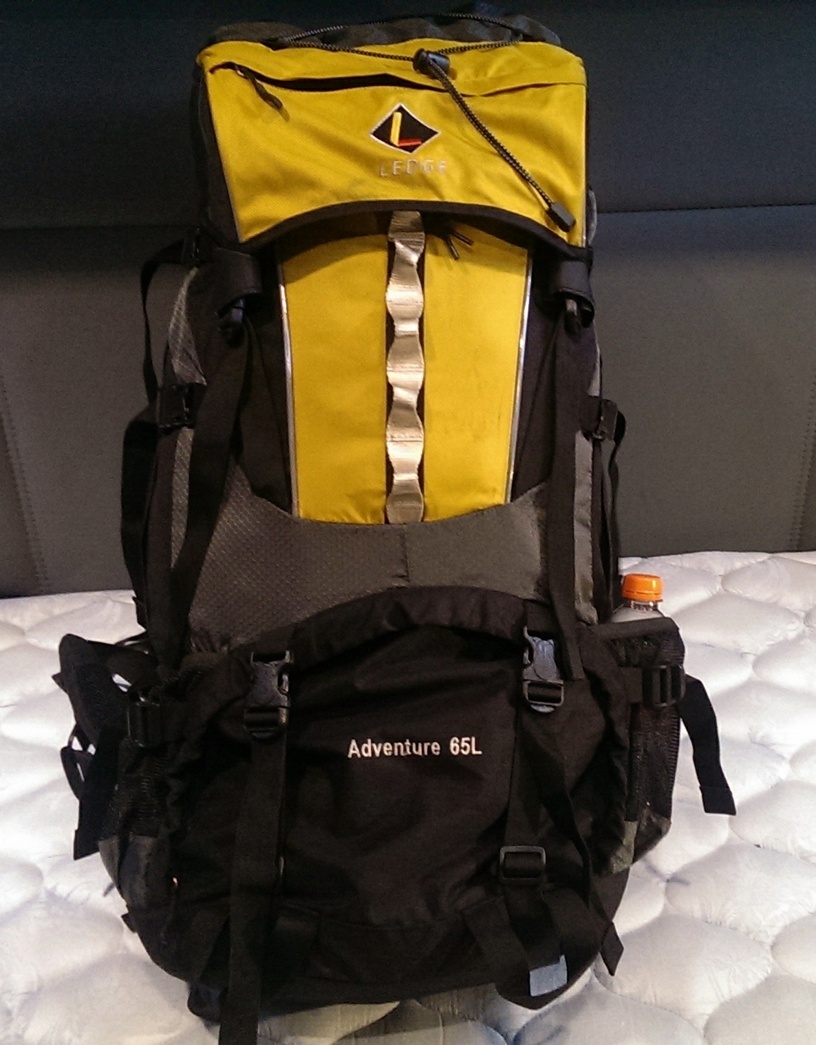 A rucksack-style backpack loaded with gear rests on the lower bunk of a semi-truck