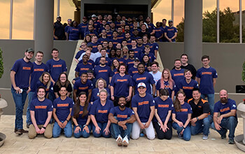 Schneider's STM team gathers on the front steps of their office in Dallas.