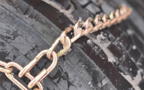 Snow chains secured on the tire on a semi-truck.
