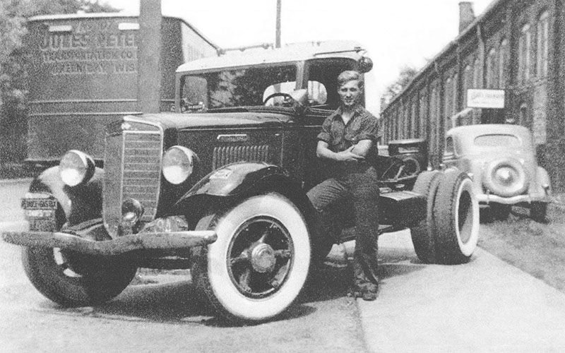Al Schneider standing in front of one of the earliest trucks he purchased after the company was founded in 1935.