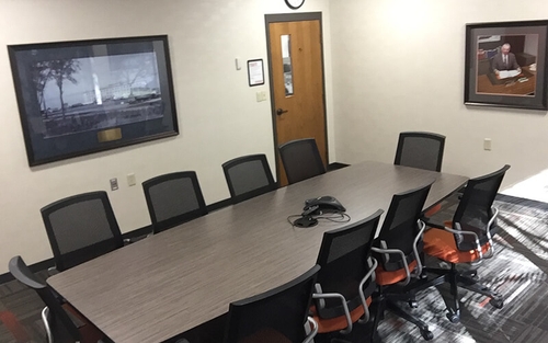 A Schneider conference room with a long table and signature orange chairs sits ready for the next meeting