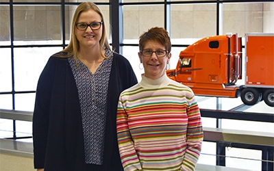 Schneider associates Toni Wicker and Angie Van Lanen pose together at the company's corporate headquarters.