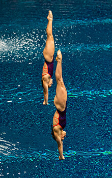 Krysta Palmer and Alison Gibson, dive head first-into a pool.