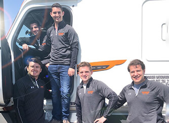 Five Schneider interns pose in and around a Schneider truck