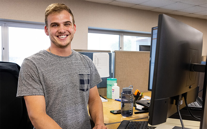 A Schneider associate standing at his desk.