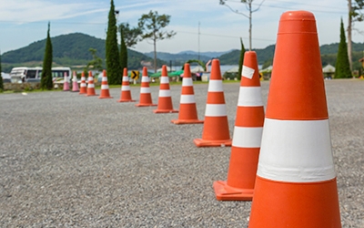 Traffic cones line the edge of a driving course at a truck driving school.