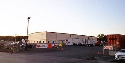An outside view of Schneider's Shrewsbury facility shows five service bay doors leading to the maintenance shop.