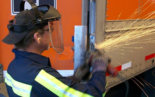 Sparks fly as a Schneider diesel technician performs a repair on a company trailer