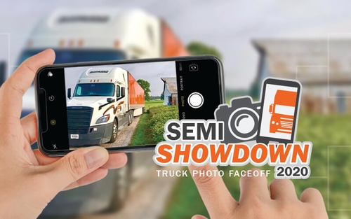 A truck driver uses their phone to snap a photo of their company truck for Schneider's 2020 semi showdown truck photo faceoff.