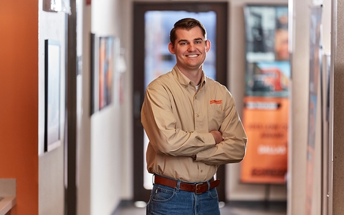 A Schneider sales representative poses in the hallway of the corporate office.