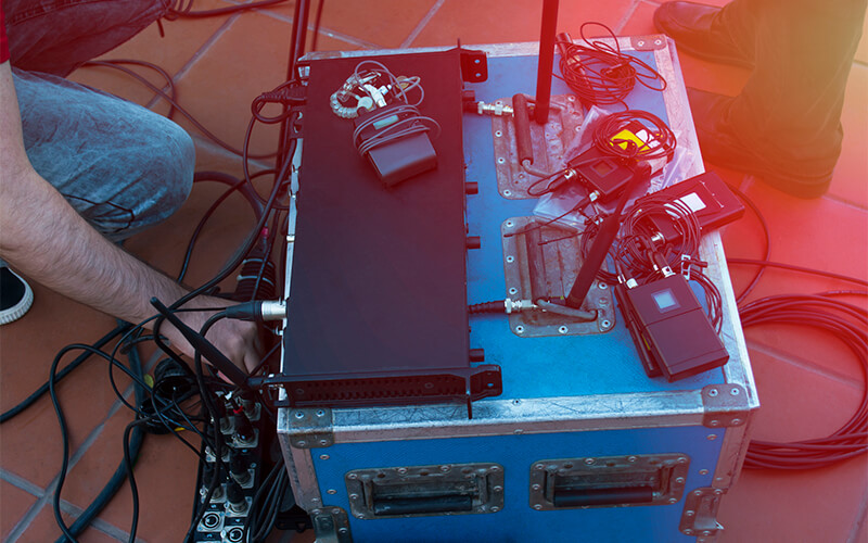 A roadie sets up sound equipment at a music venue.