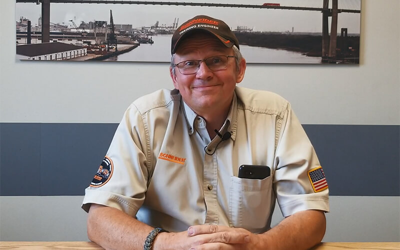 Brian Johnson is seated and smiling in his Training Engineer uniform.