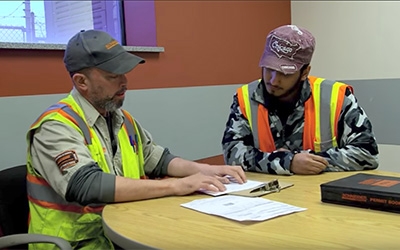 A Schneider leader and driver sit together and review documents at a table