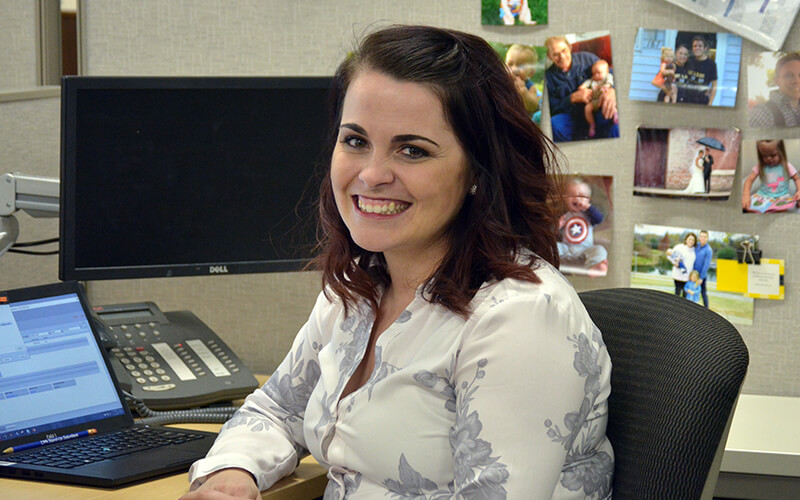 Schneider associate Kate sits at her desk, surrounded by photos of friends and family.