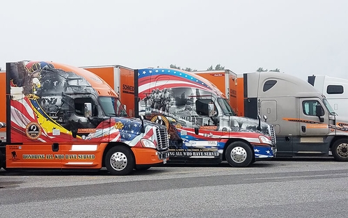 Two Schneider Ride of Pride trucks lined up in a truck lot
