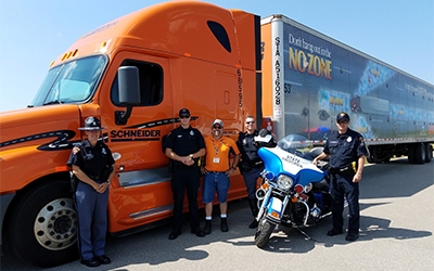 Schneider tractor-trailer with driver and police officer