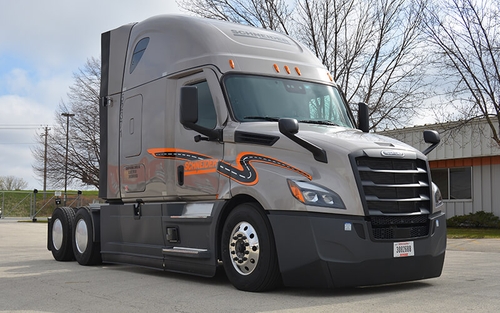 A grey Schneider 2022 Freightliner Cascadia is parked outside of Schneider's Green Bay operating facility.