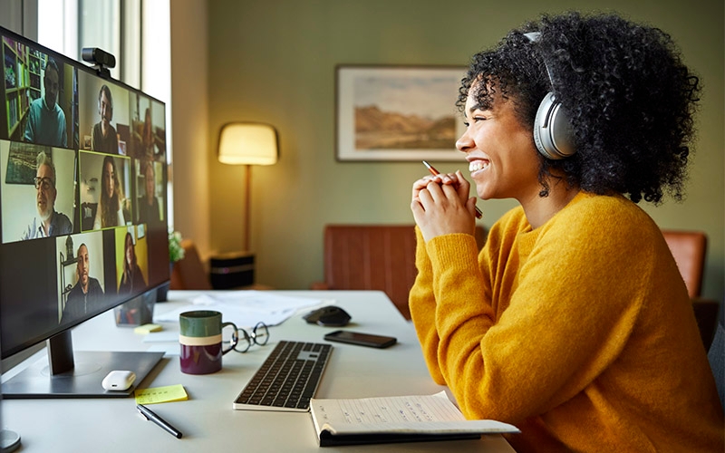 A woman working from home smiles during a video call.