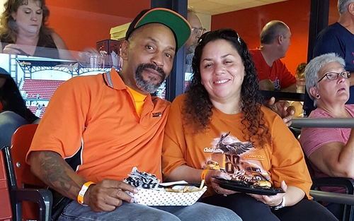 Two Schneider Advantage Club drivers pose together wearing orange Schneider shirts at a sporting event