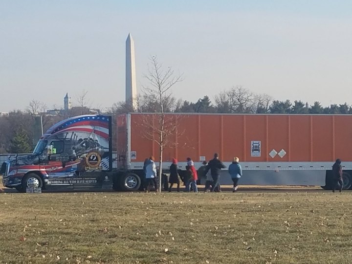 Volunteers unload wreaths off of trailer for Wreaths Across America