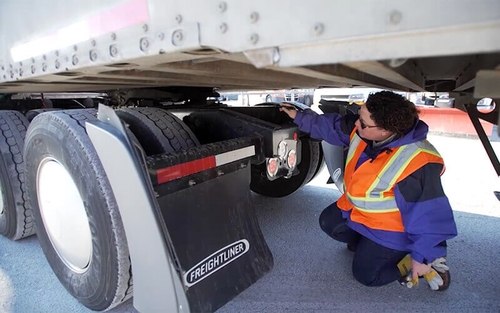 Schneider Driver Instructor Dana performs a CDL pre-trip inspection.