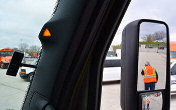 The Side Guard Assist warning system displays a lit triangular warning light to indicate that there is a pedestrian in the passenger side lane.