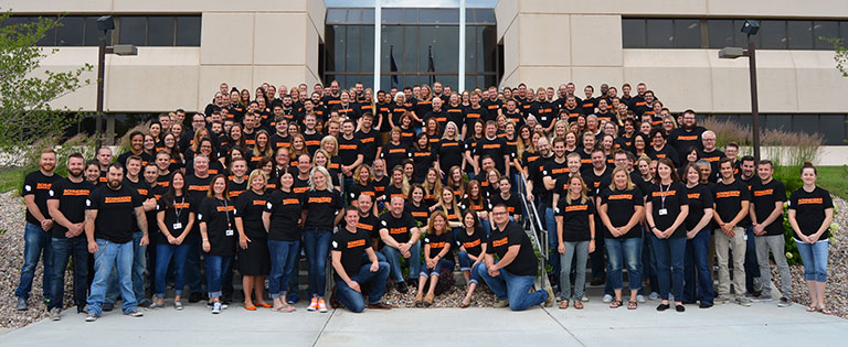 A large group of Schneider Transportation Management associates gathers on the steps leading up to the Ridge Business Center in Green Bay, Wis.