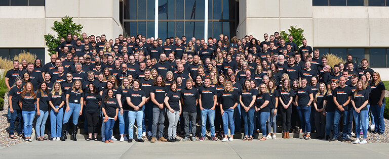 A large group of Schneider Transportation Management associates gathers on the steps leading up to the Ridge Business Center in Green Bay, Wis.