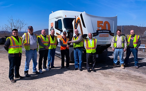 Schneider associates pose with the new decal recognizing the 50th anniversary of Schneider’s Bulk division.