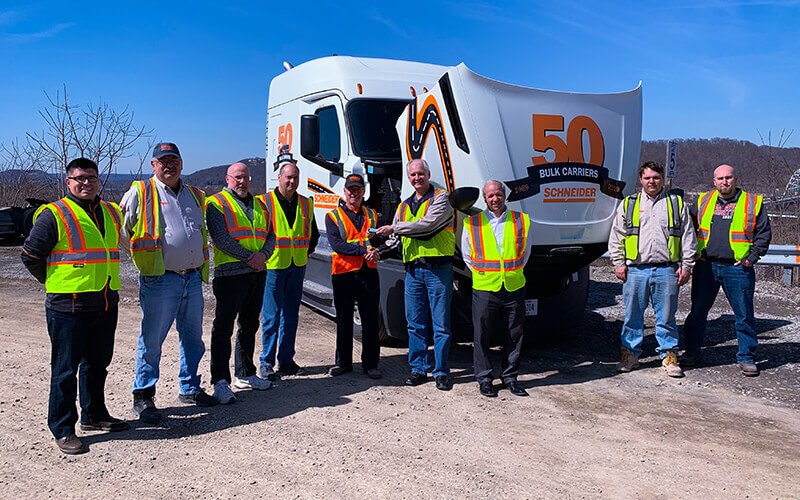 Schneider associates pose with the new decal recognizing the 50th anniversary of Schneider’s Bulk division.