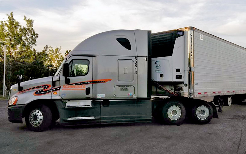 A parked Schneider truck with a reefer trailer attached.