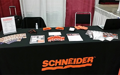A Schneider recruiting booth with career information and stress balls shaped like semi-trucks