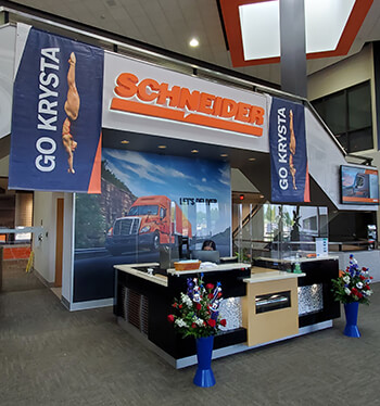Posters of Krysta Palmer diving and red-white-and-blue flower pots decorate the front lobby of Schneider's headquarters.