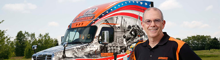 A Schneider Ride of Pride driver poses in front of his military-tribute company truck.