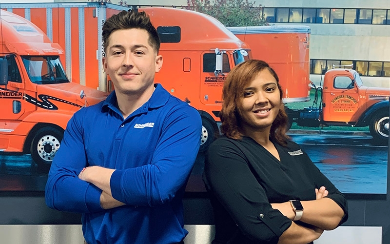 Juan Durazo and Hayley Lee standing with their arms crossed in front of a Schneider wall.