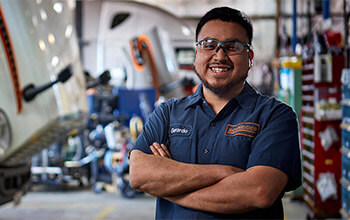 Senior diesel technician standing near the service bays in a Schneider facility.