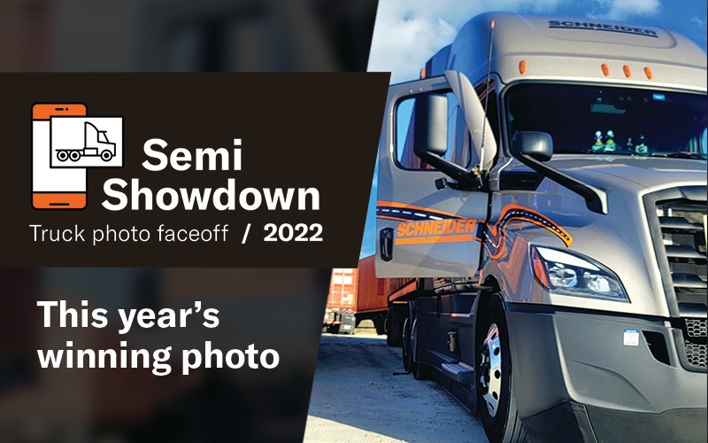 A grey Schneider tractor has it's door open, displaying the orange Schneider logo on it's surface. To the left of the tractor is text that says "Semi Showdown truck photo faceoff, 2022. This year's winning photo."