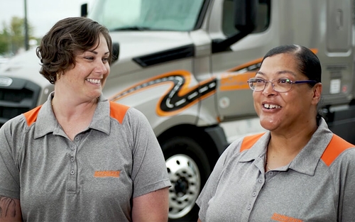 Schneider drivers Lisa and Patrice smile at each other while discussing their journey together as Army friends and team drivers