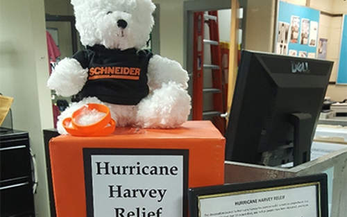 A teddy bear sports a Schneider tee while sitting atop a Hurricane Harvey Relief fund