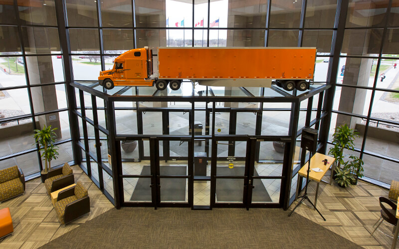 A replica of a Schneider truck and trailer sits stop the doorway leading into the company's corporate headquarters.