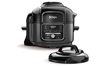 A black Ninja Foodi pressure cooker and lid sit in front of a white background.