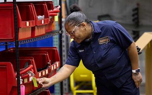 A female Schneider diesel shop manager checking inventory inside a shop.