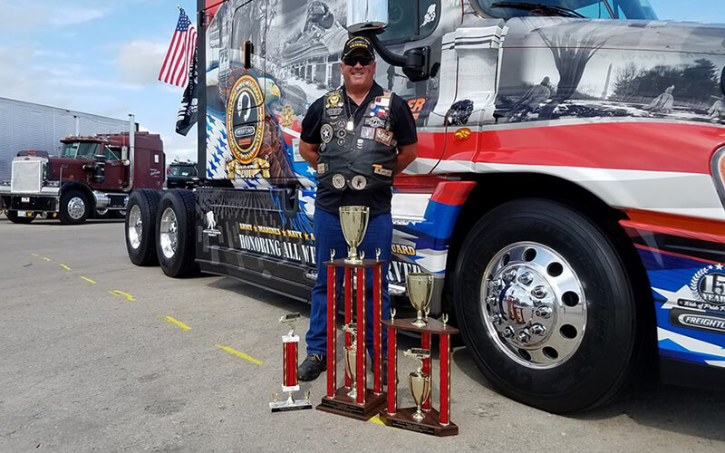 2015 Schneider Ride of Pride drive Jay Hull poses with trophies in front of his winning truck