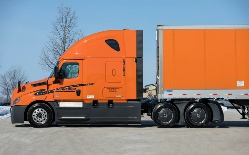 Side profile of the Schneider Freightliner P4 truck shows a winding road decal along the door and front quarter panel