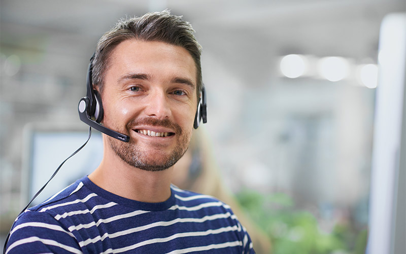 A man wearing a headset and smiling.