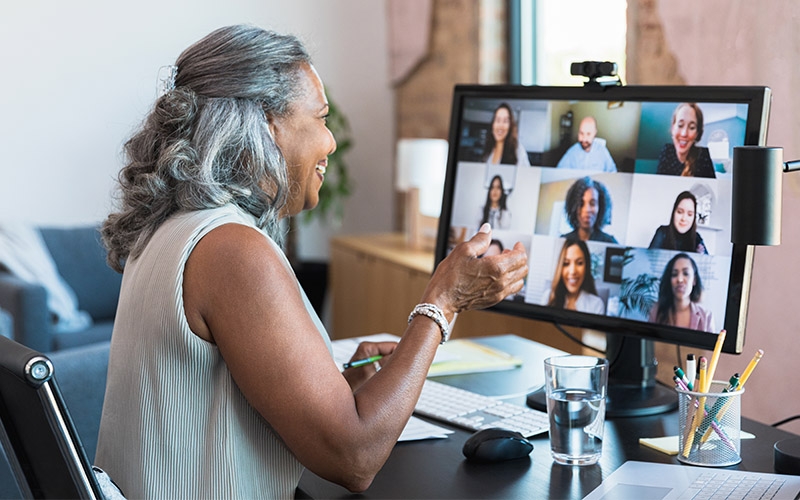 A woman meets with her team on her computer.