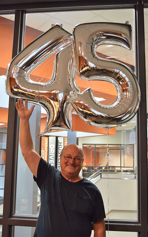 Bob celebrates his work anniversary at Schneider with a pair of balloons that make out the number 45.