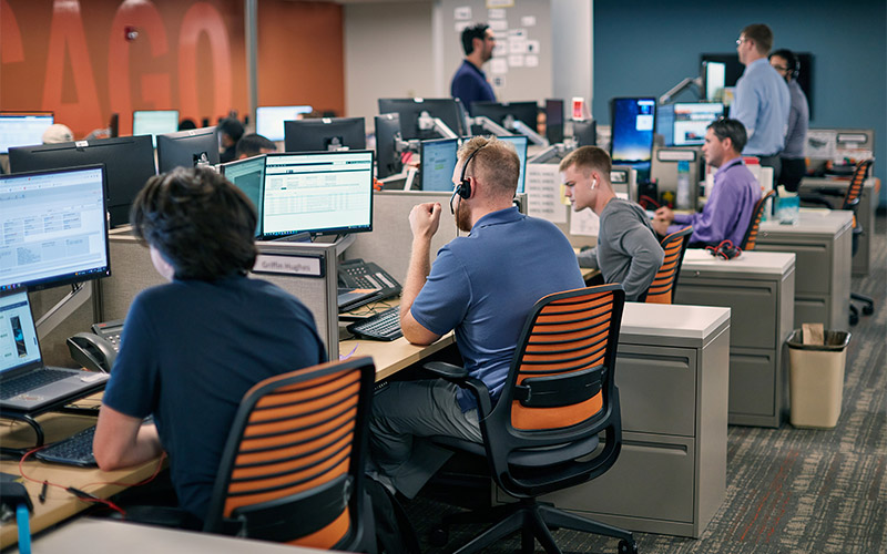 Freight brokers sitting at their desks in an office.