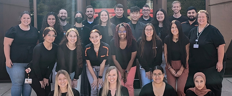 A large group of Schneider driver recruiters stand in front of a Schneider facility