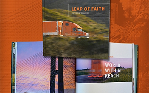 Schneider's "Leap of Faith" history book cover and inside spread with photos of company trucks passing through various landscapes